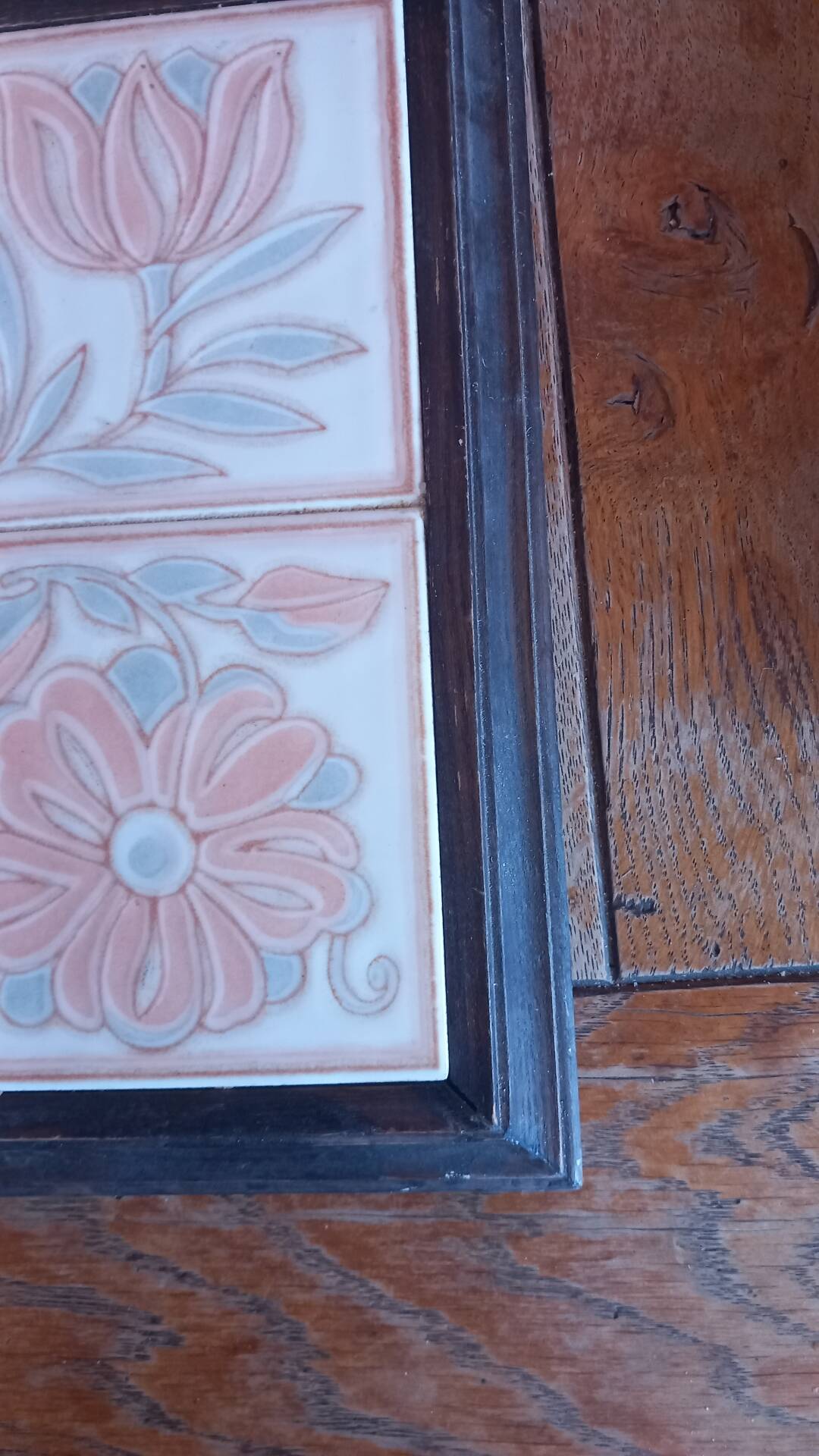 Ceramic tile trivet with floral patterns in pastel tones.