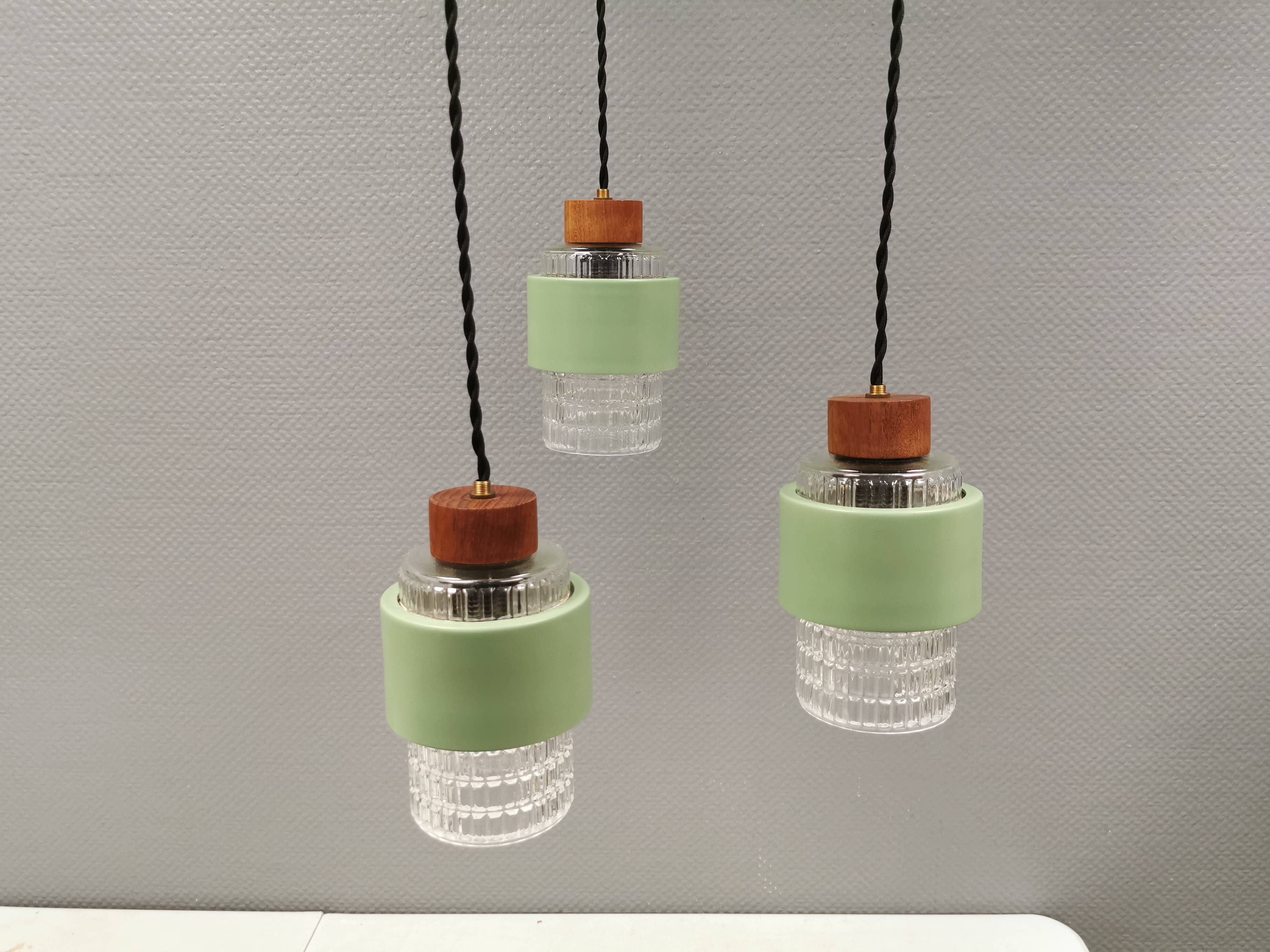 Three-part pendant in crystal glass, teak wood, and thin dusty green metal