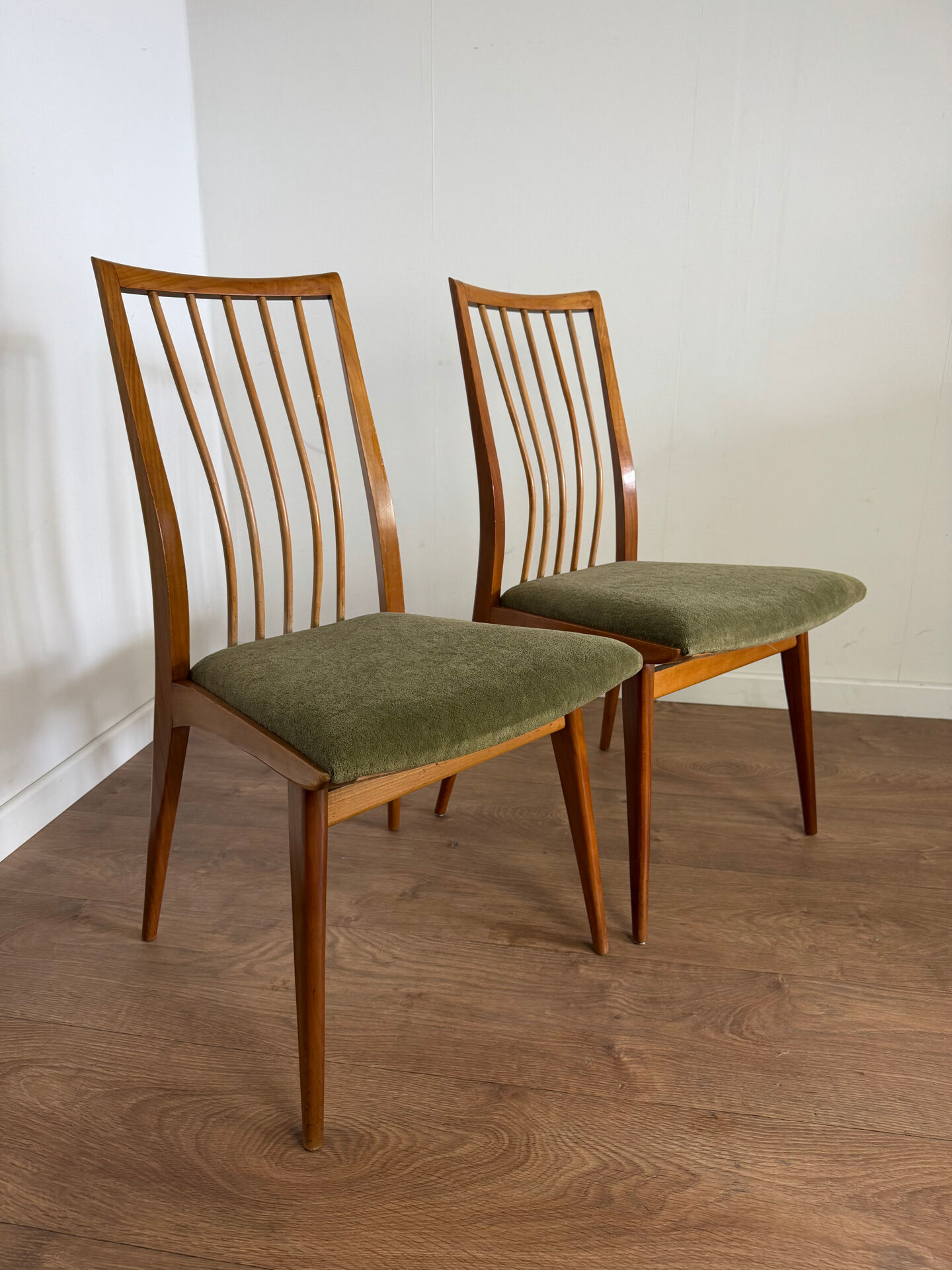 Scandinavian chairs with green velvet upholstery.