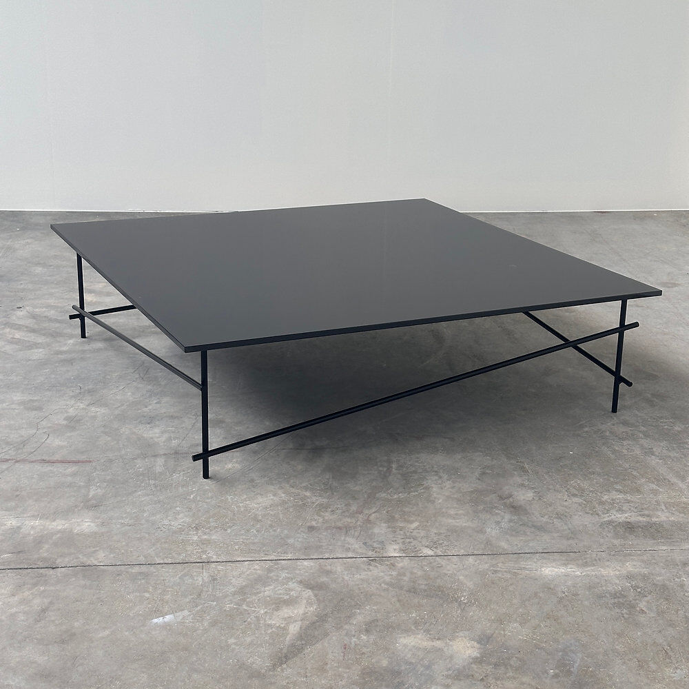 Minimalist black glass coffee table with industrial metal base
