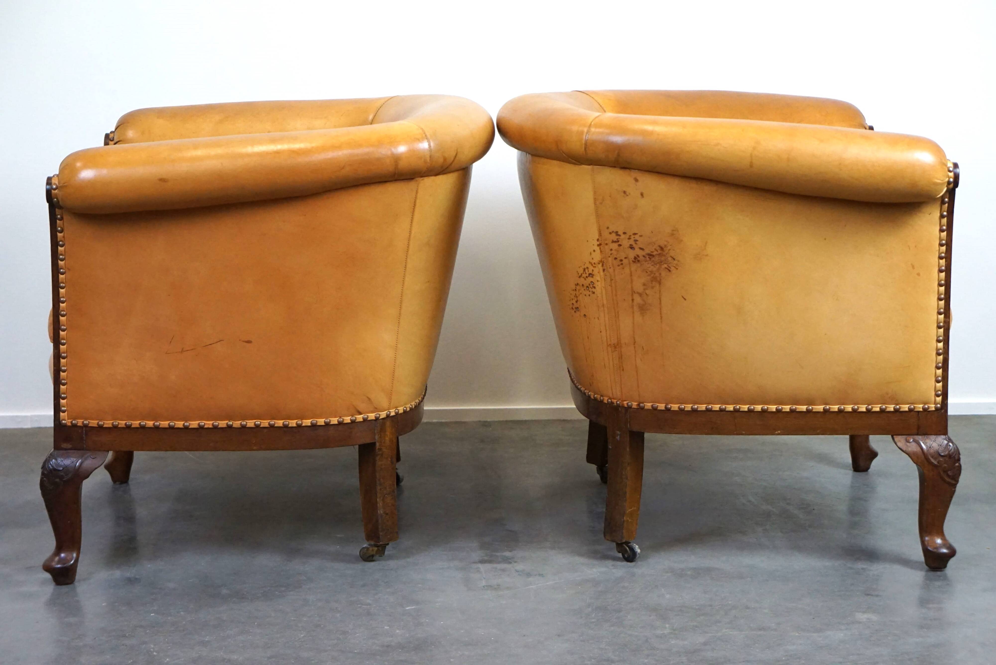 Unique old set of 2 club armchairs and a couch in cognac-colored leather with wheels