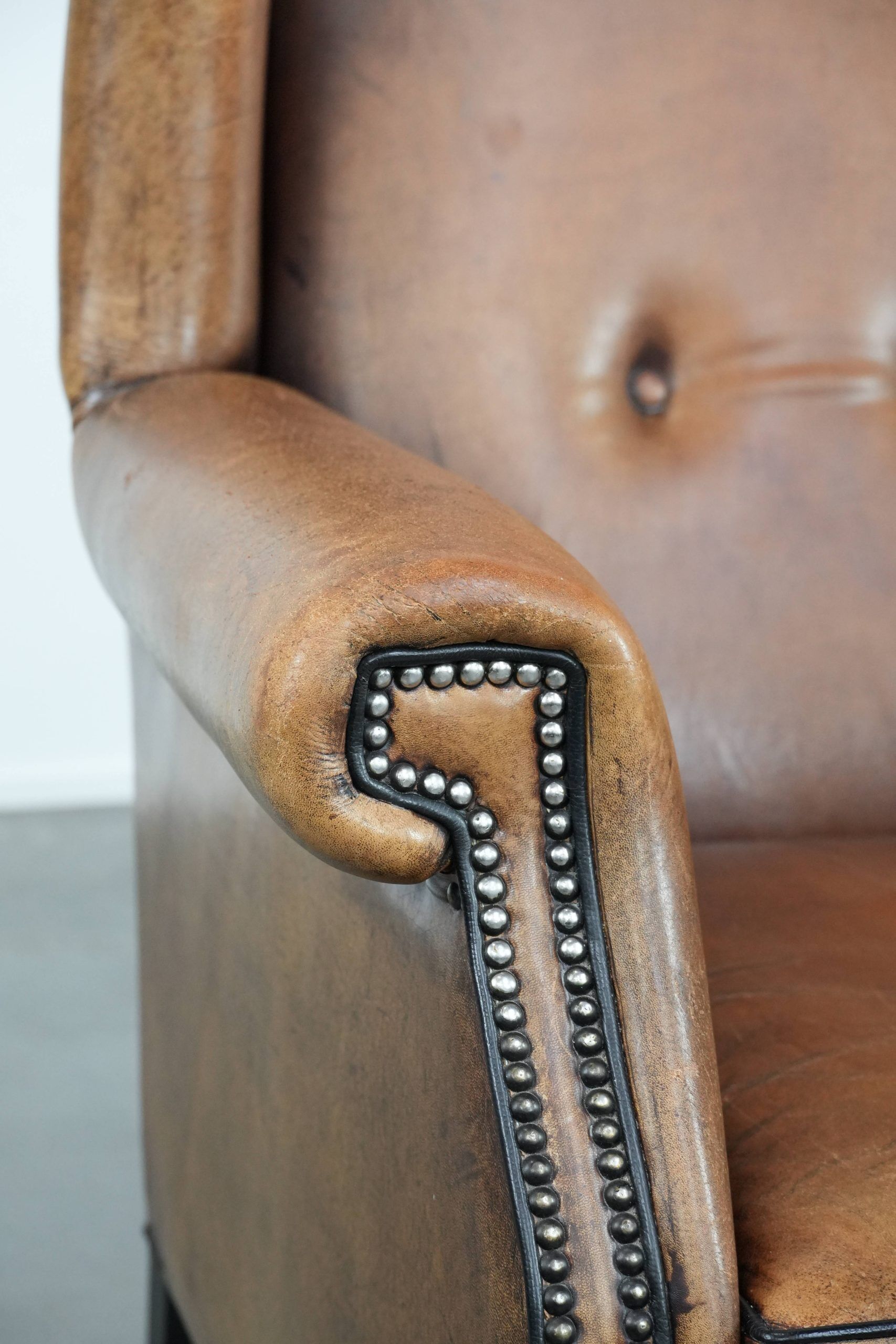 Large and comfortable sheepskin leather wingback chair with black piping