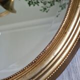 Oval mirror beveled gilded, wooden frame and stucco