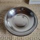 Shallow round metal plate with pearl bead decoration.