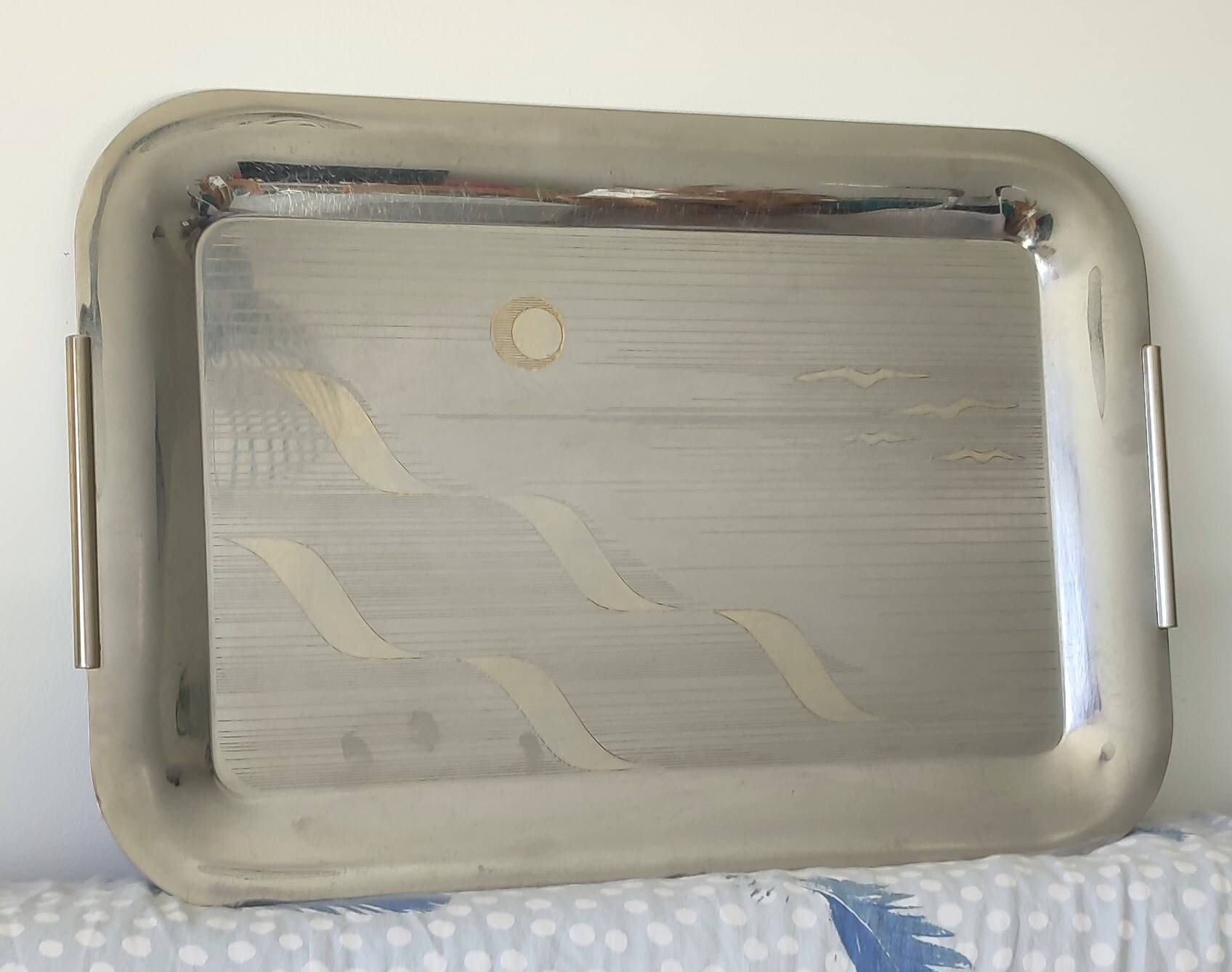 Vintage stainless steel serving platter with marine decor and golden handles.