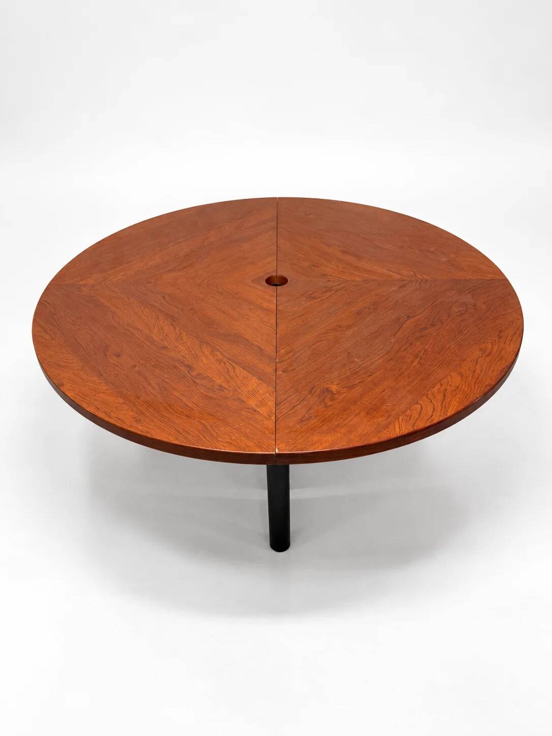 Large round dining table with black blade legs.