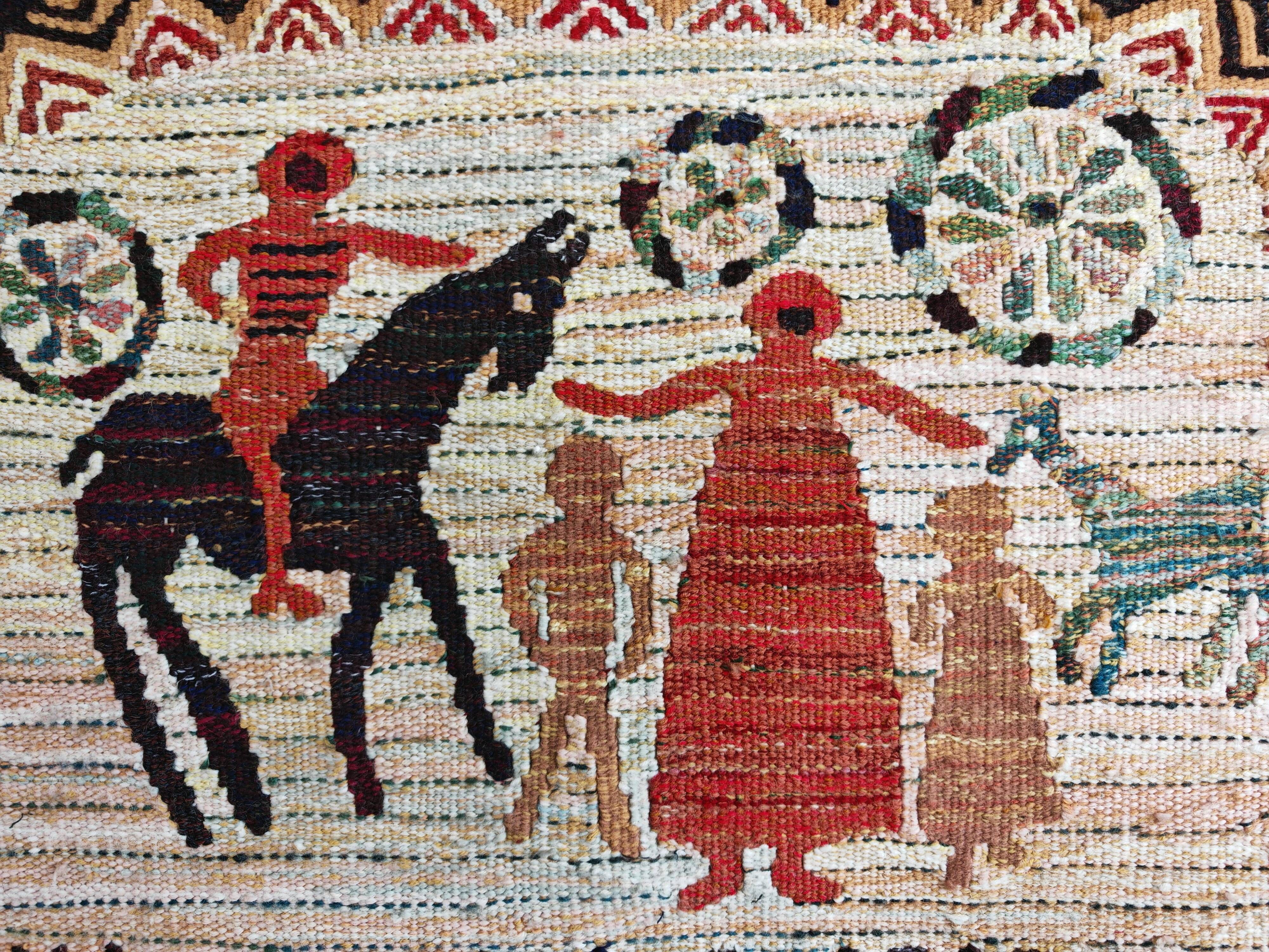 Vintage handwoven tapestry with a folk scene and archaic Slavic writing.