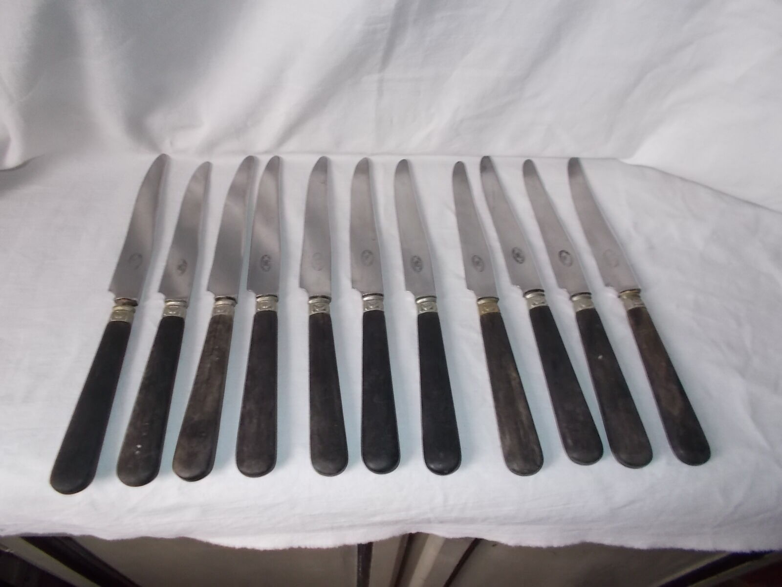 Set of 11 black wooden sleeve knives