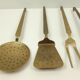 5 kitchen utensils and a brass wall mount