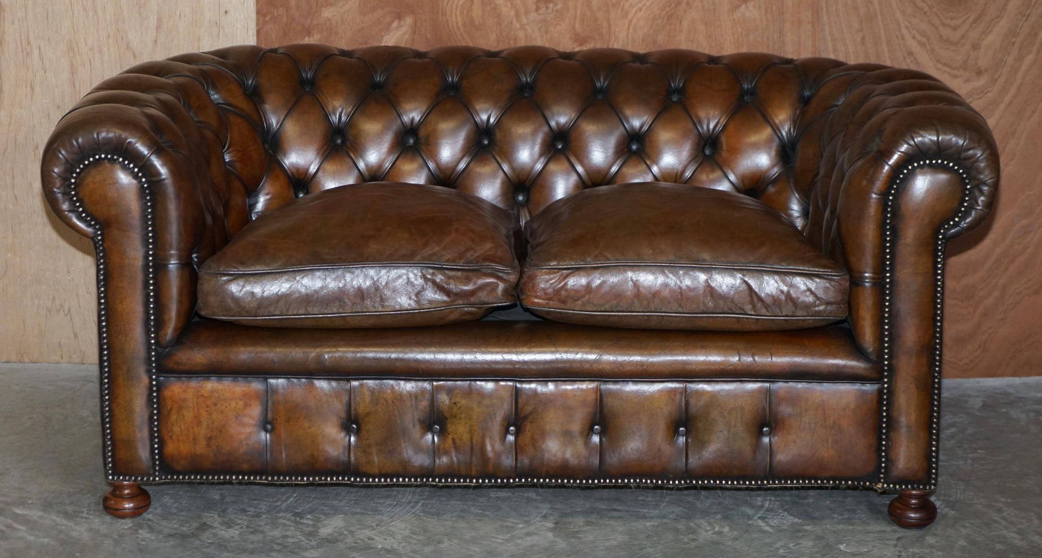 Restored leather Chesterfield sofa, walnut legs.