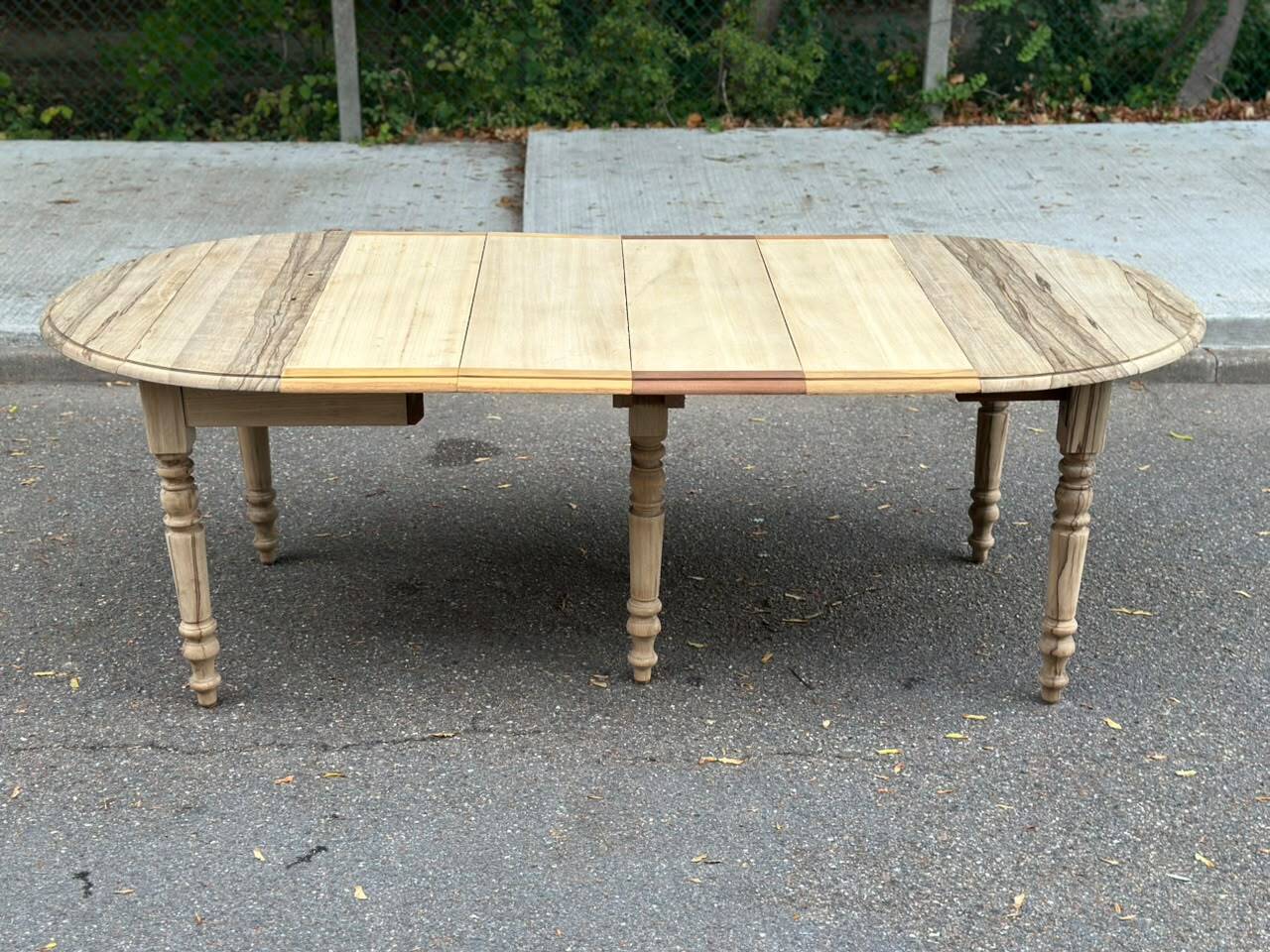 Round extendable dining table with flaps, stripped in raw oak, with 4 extensions.