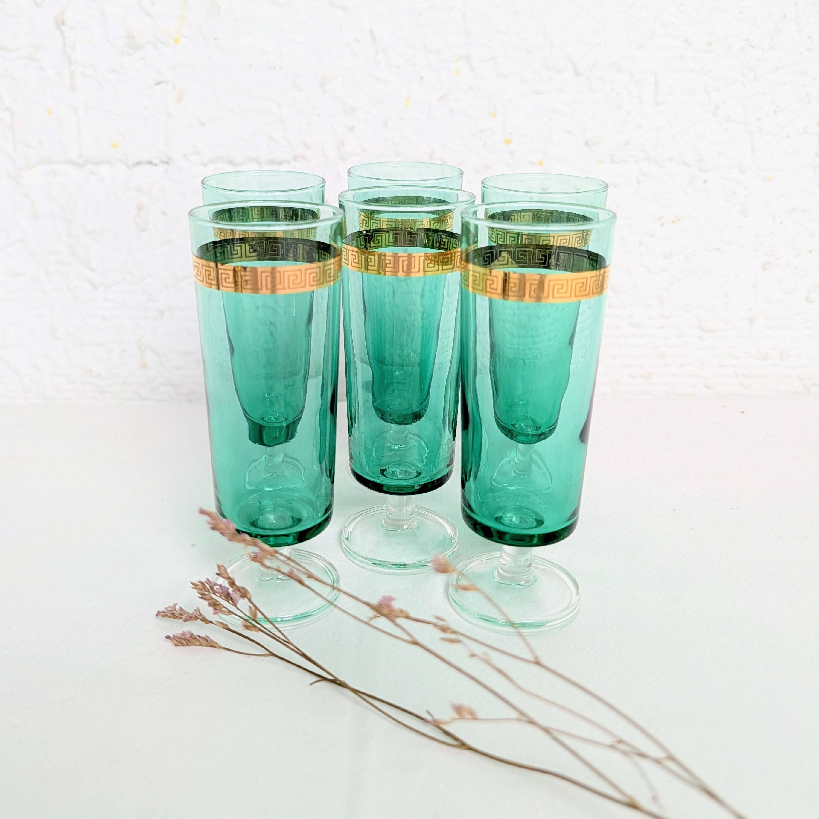 Set of 6 green champagne flutes with a golden rim.