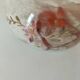 Red-orange glazed ceramic workshop bowl with floral decoration.
