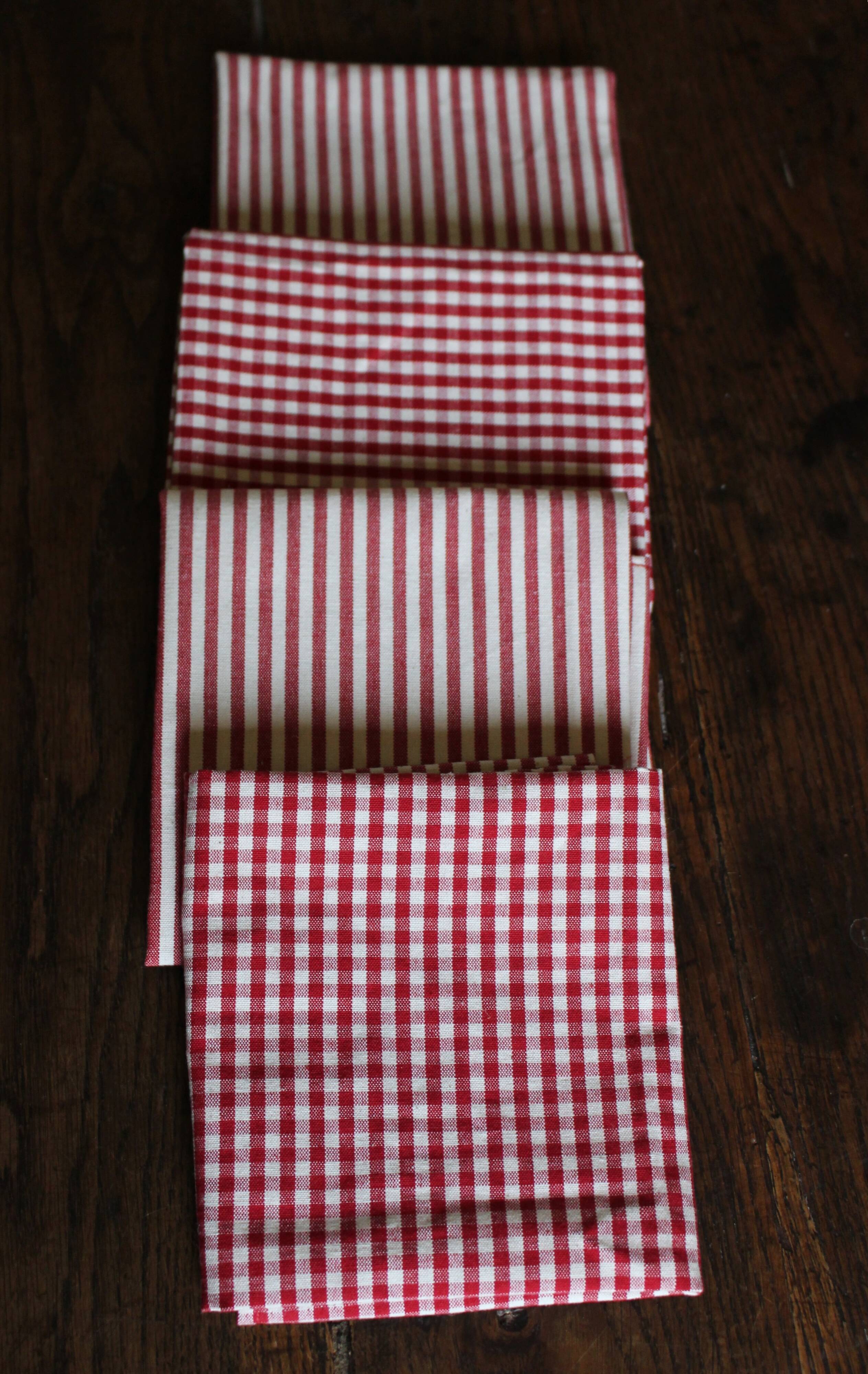 A set of 4 red striped and checkered napkins.