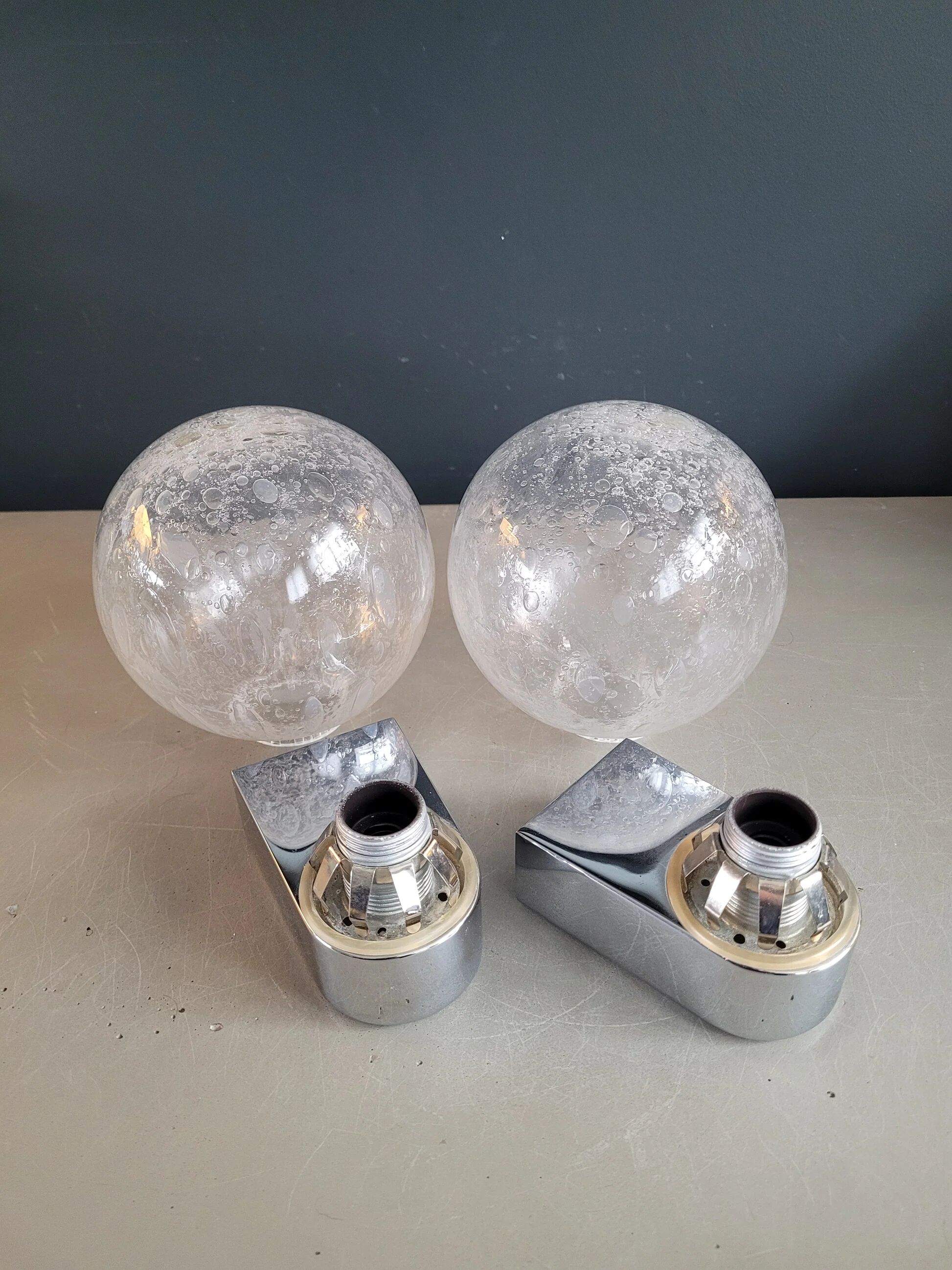 Pair of vintage wall lights in chrome metal with bubbled glass globes.