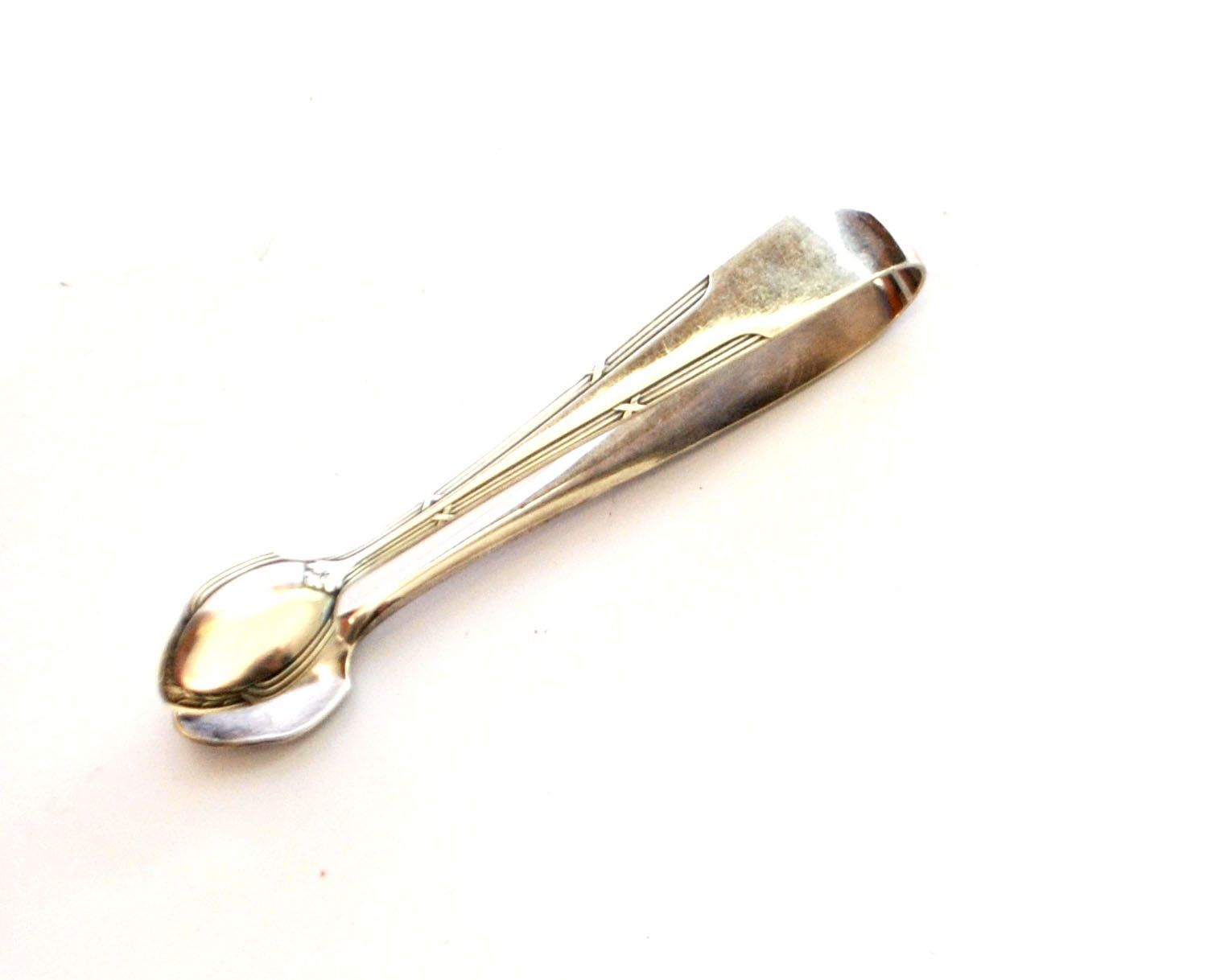 WMF vintage sugar tongs in silver-plated metal with crossed ribbon decoration.