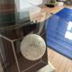 Table basse vintage en verre avec piètement trompe-l’œil livres