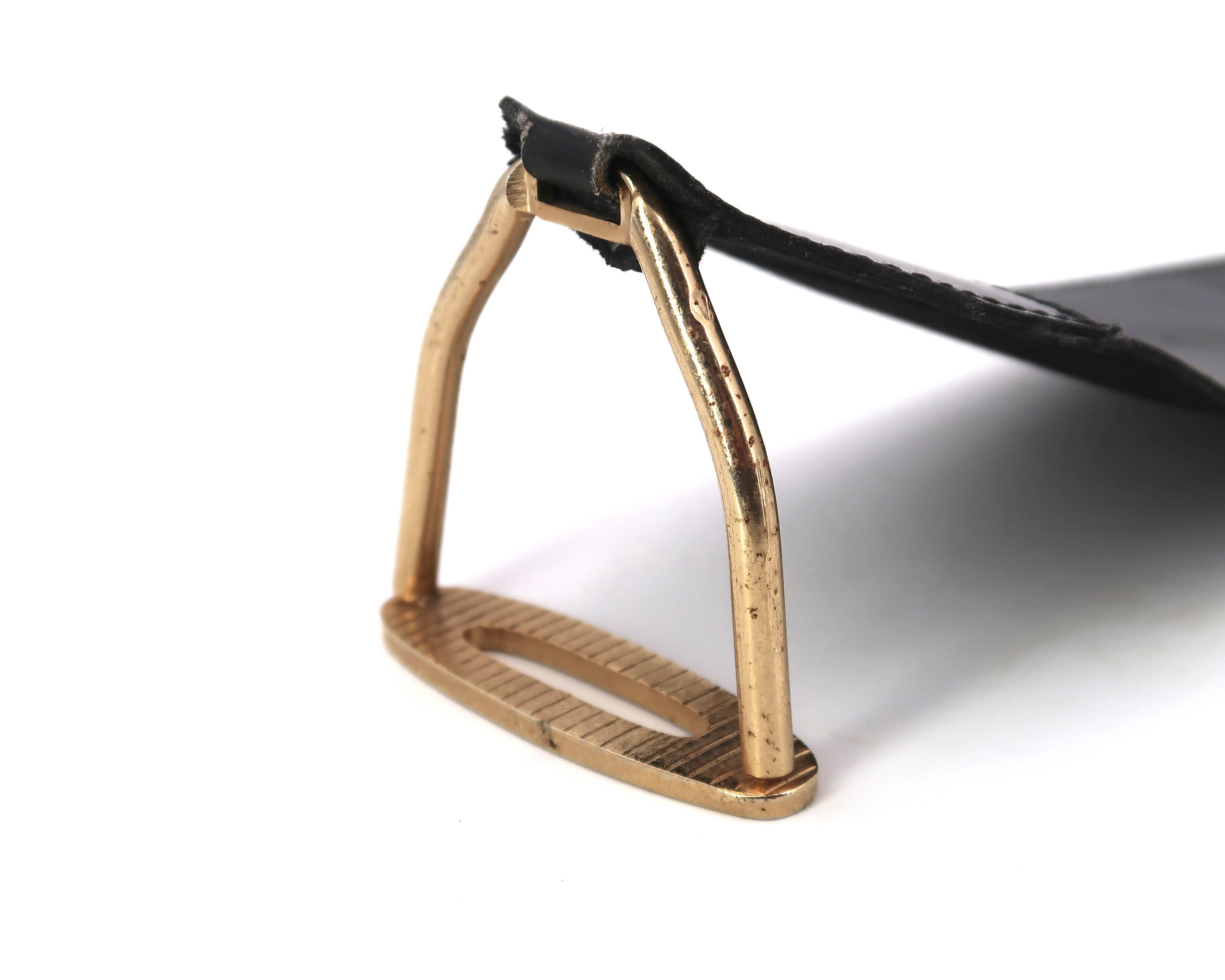 Golden metal armrest ashtray with faux leather and stirrups, 1950s.