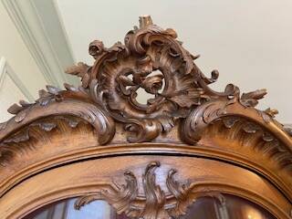Large wooden display cabinet in Louis XV/rococo style with a strongly curved front.