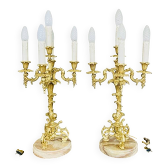 Massive gilded bronze chandeliers from the mid-20th century with marble bases.
