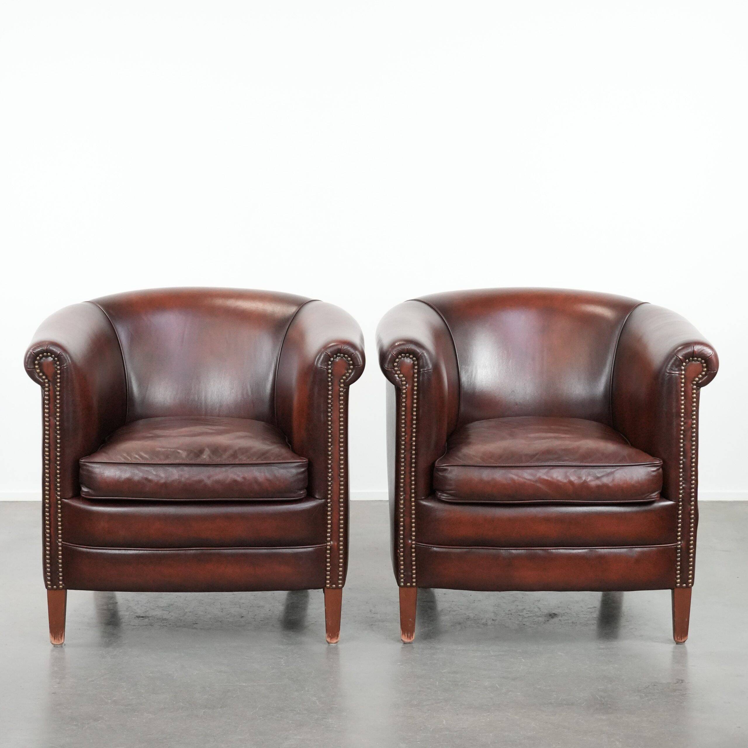Set of two cow leather club armchairs in a luxurious red/brown colour