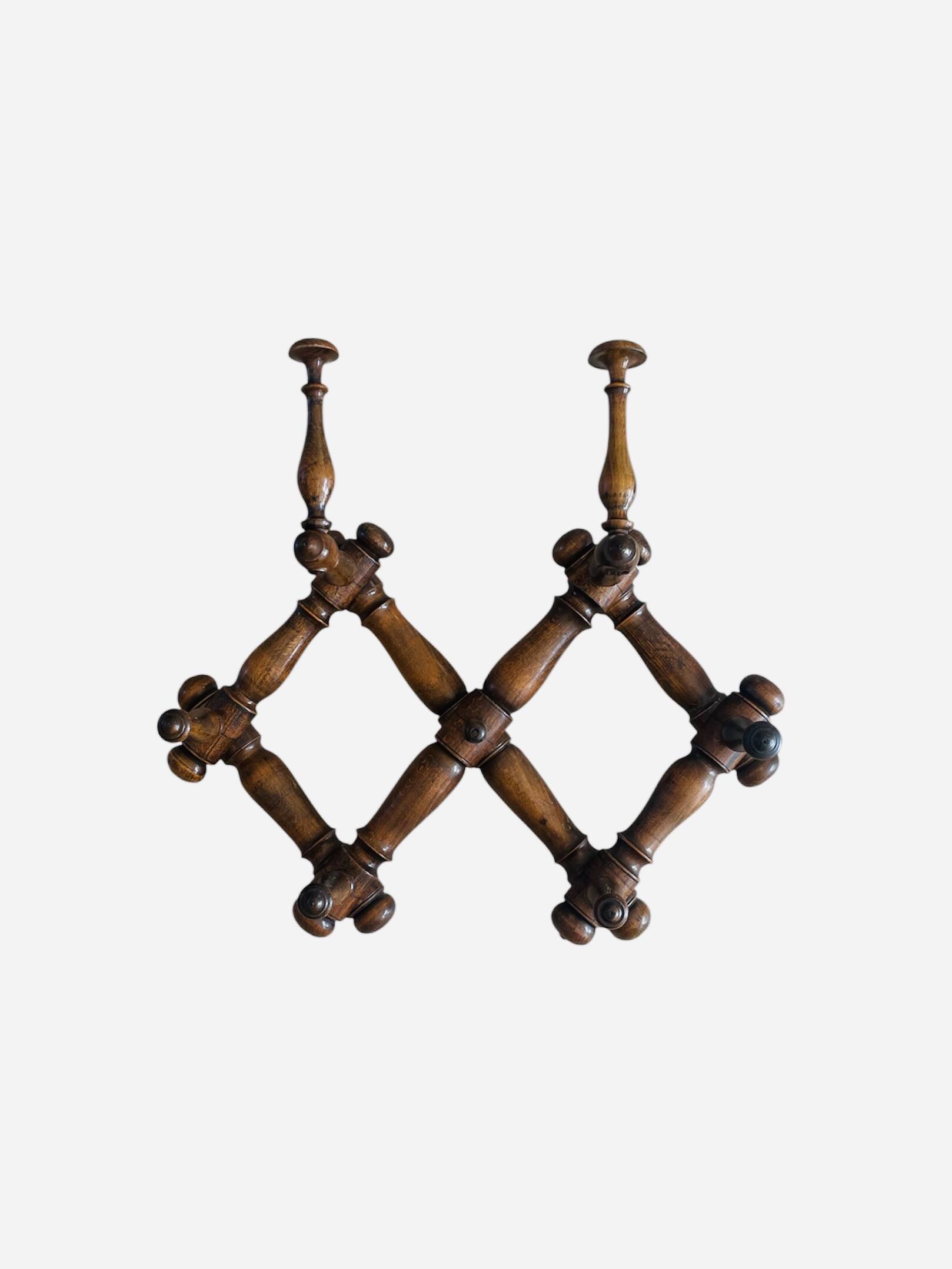 Wall-mounted accordion coat rack made of turned wood