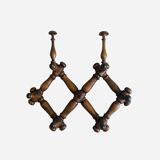 Wall-mounted accordion coat rack made of turned wood