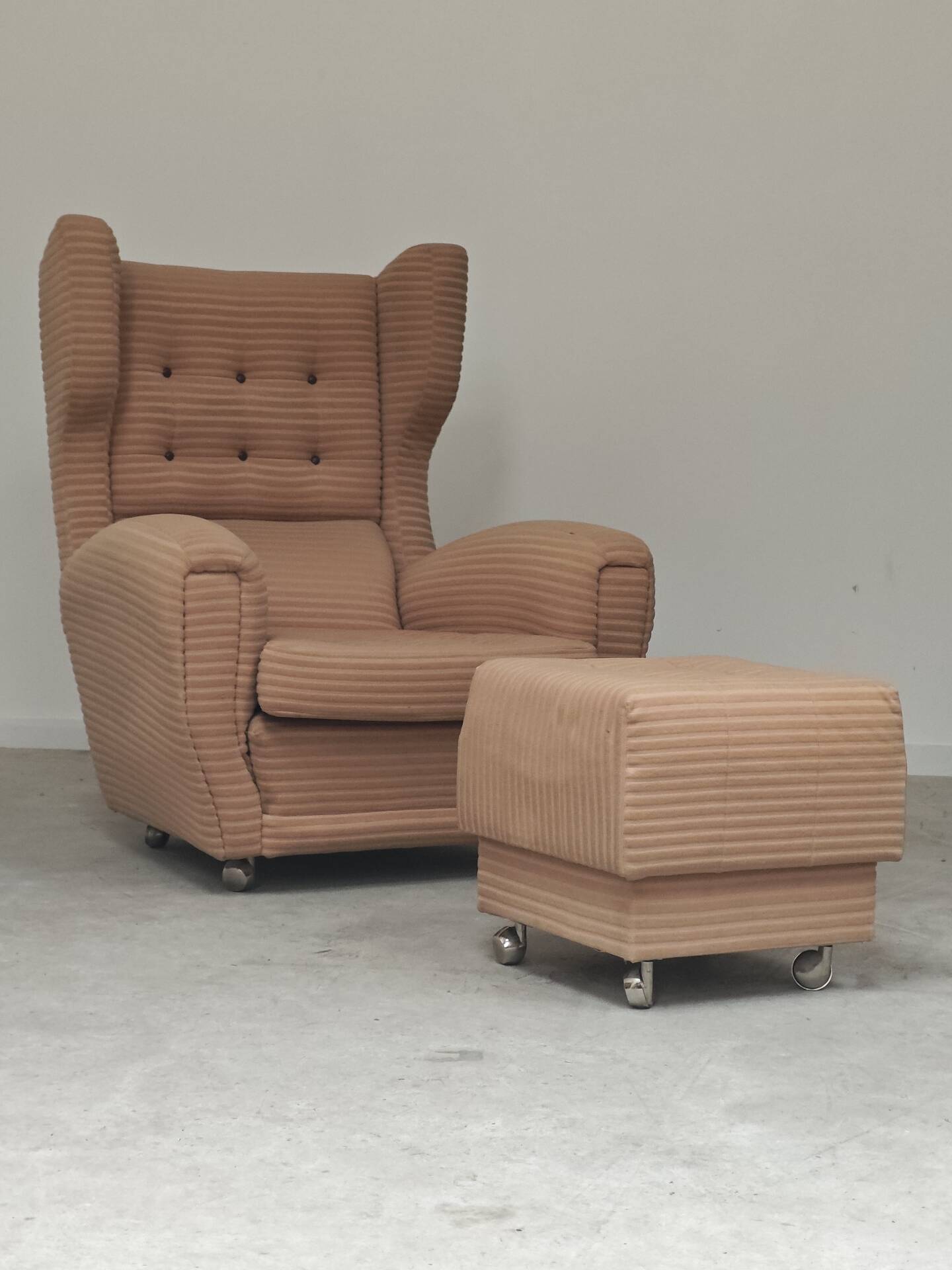 Beige wingback armchair and TVAR footrest, former Czechoslovakia.
