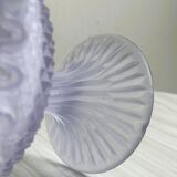Purple glass pedestal bowl with wavy border and relief pattern.