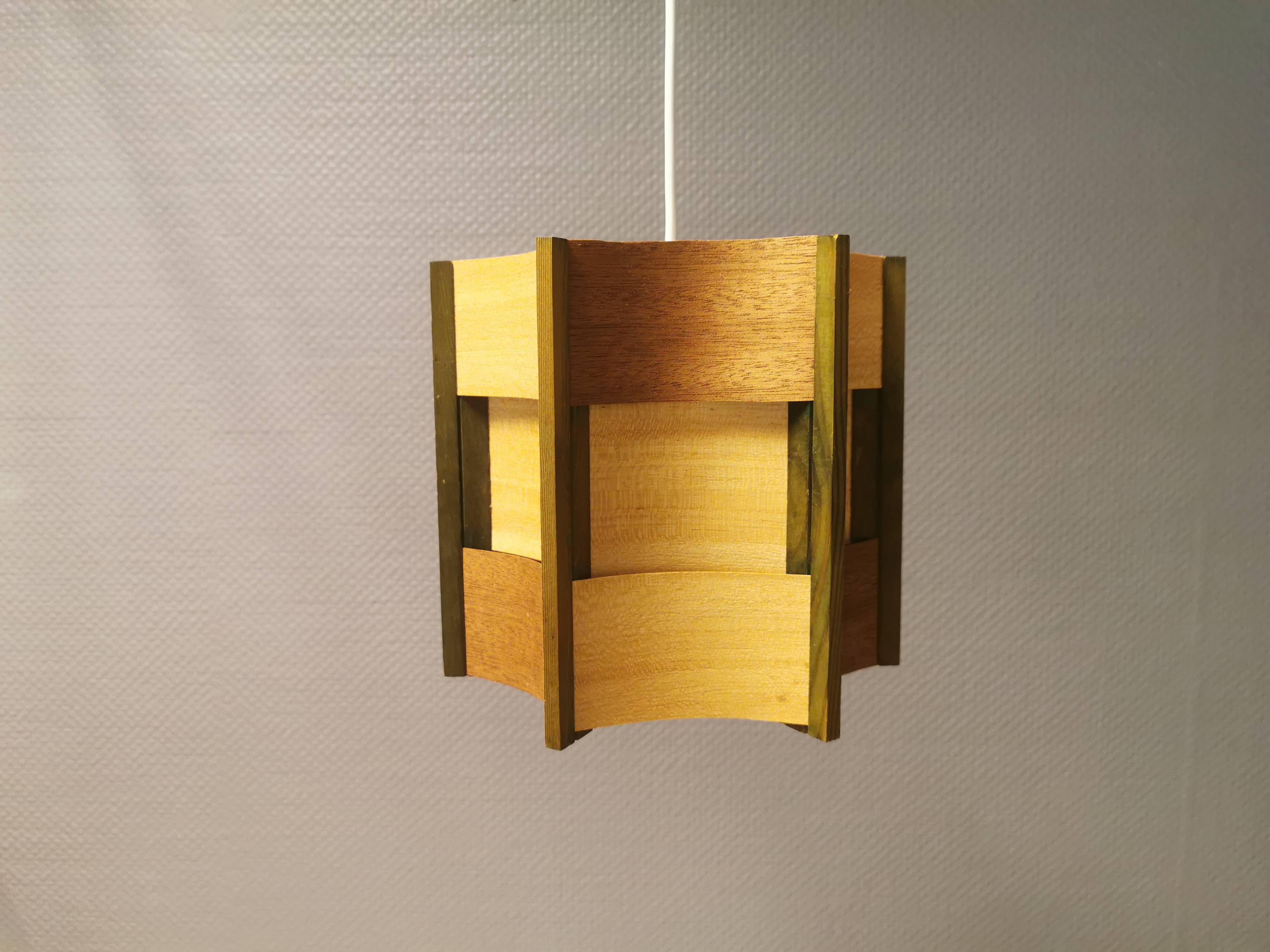 Older lamp in wood veneer, partially painted in green colour.