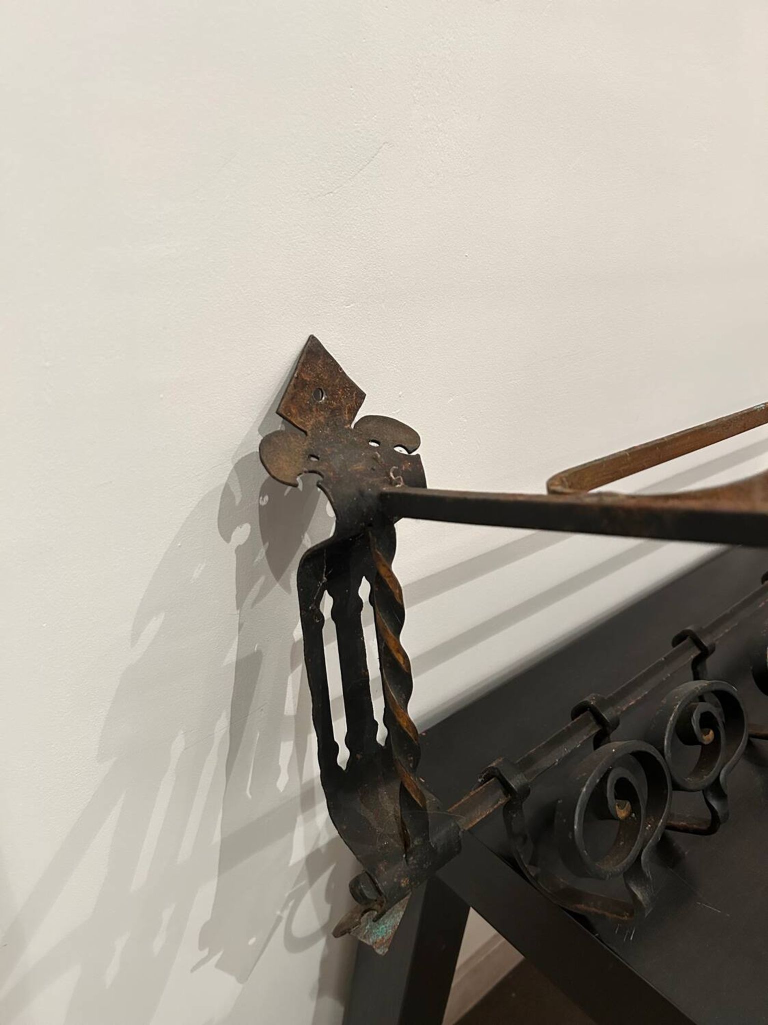 Large antique wall-mounted coat rack in wrought iron.