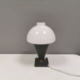 Small stylish table lamp with perforations and milky white opal glass shade