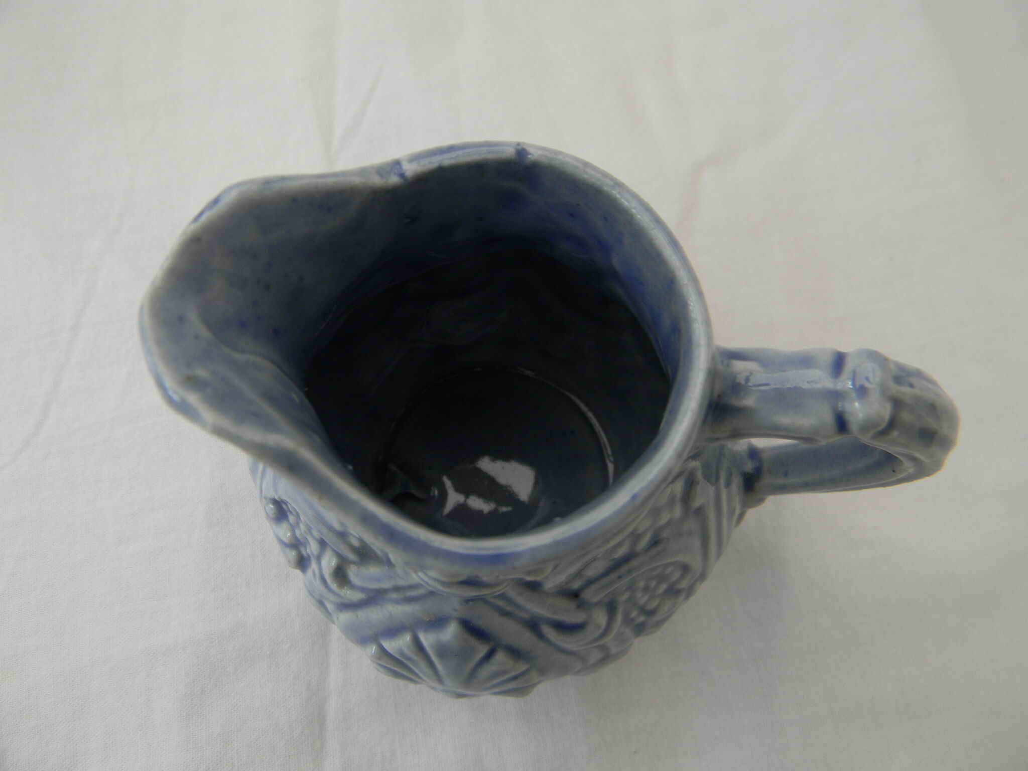 Petit pot à lait bleu en barbotine.