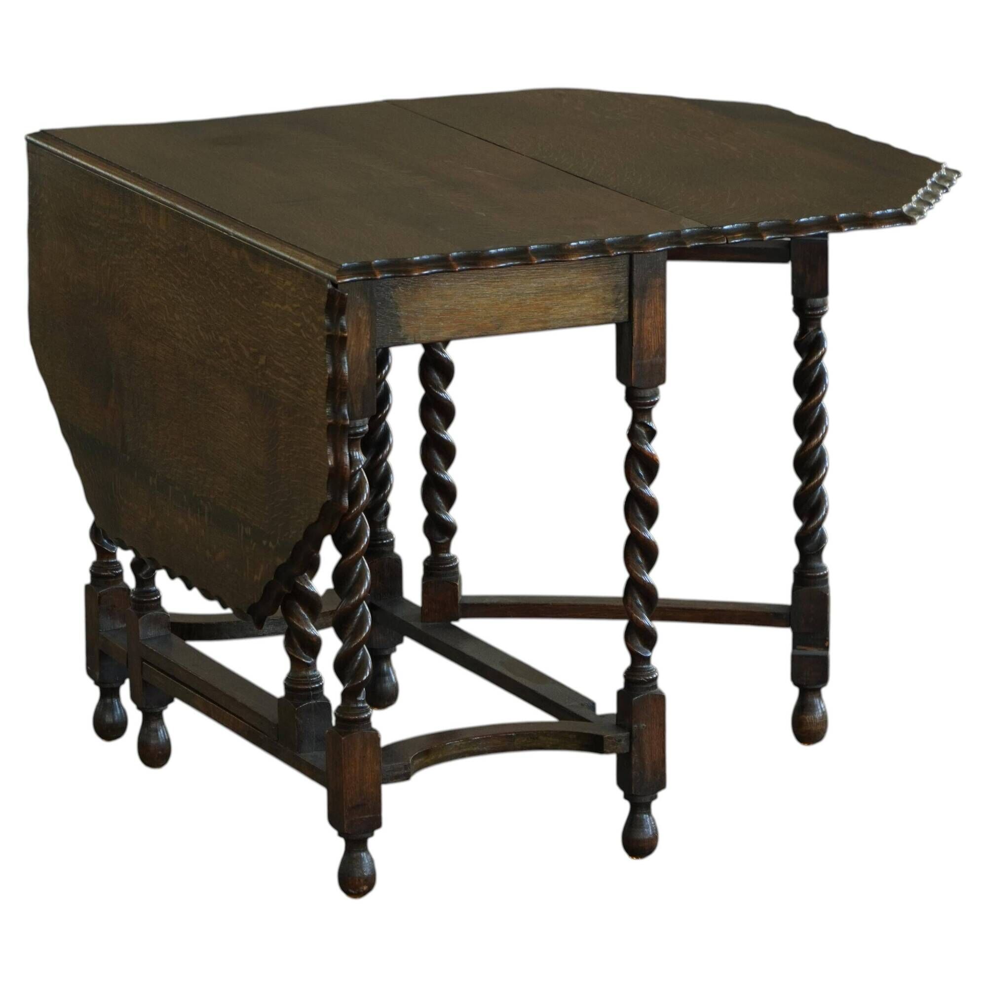 Antique baroque dining table in oak, with folding legs and drop leaves, featuring spiral "barley twist" legs, from the 1920s.