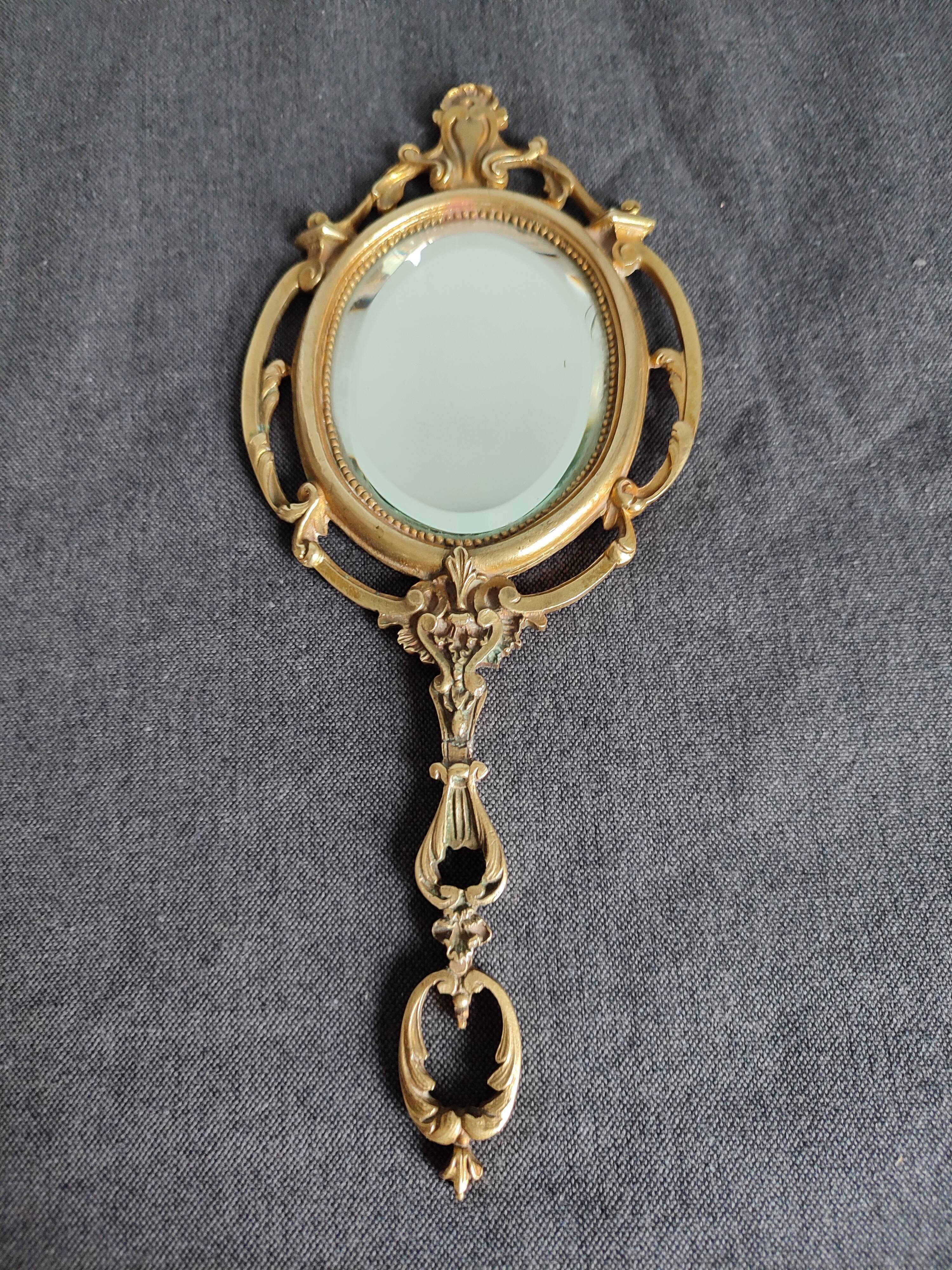 Antique hand-facing mirror in bronze and beveled glass
