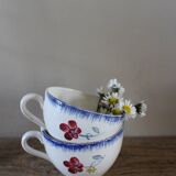 A set of two Digoin earthenware cups with blue, red, and yellow flowers.