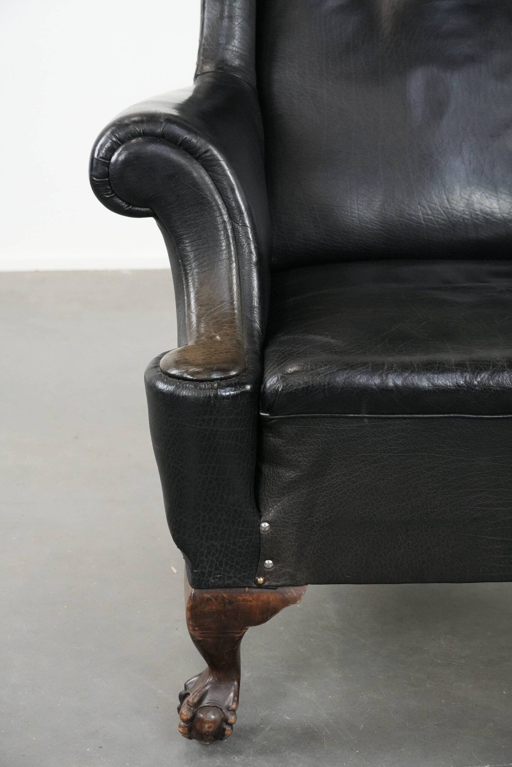Antique black English cow leather wingback armchair from the 19th century
