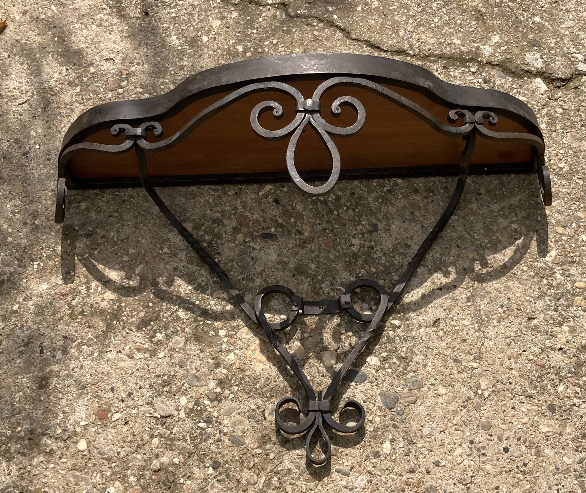 Old wrought iron console with a fleur-de-lis design.
