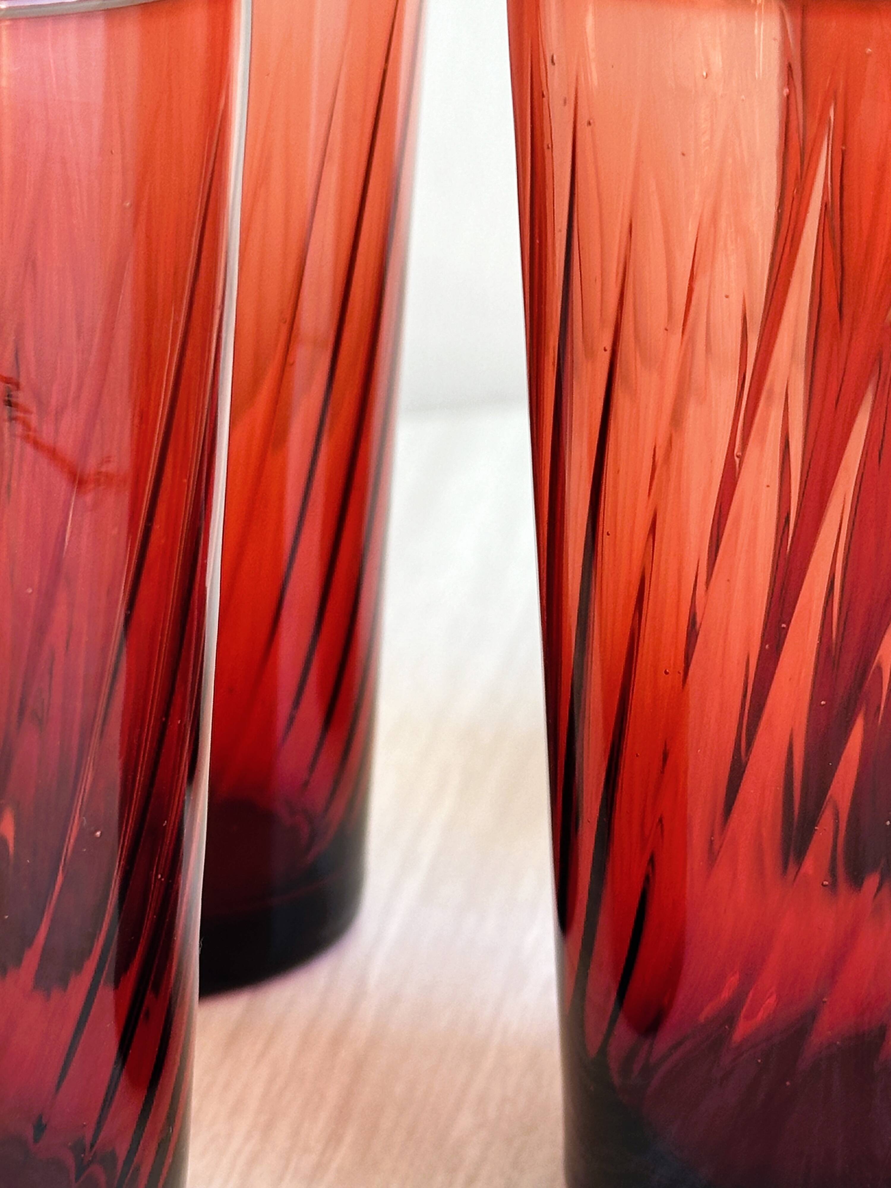 4 verres à eau rouges translucides.