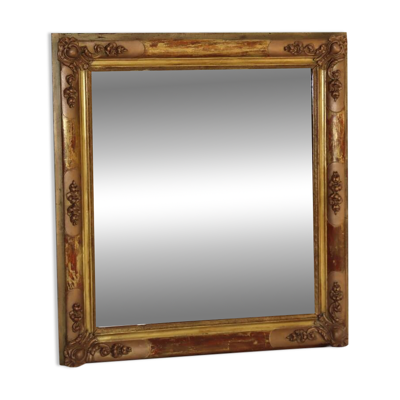 Miroir rectangulaire en bois doré à décor en relief de fleurs.