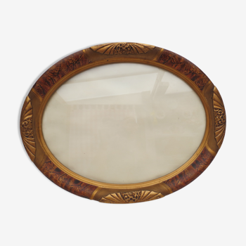 Old oval wooden frame in art nouveau style glazed flamed and gilded color