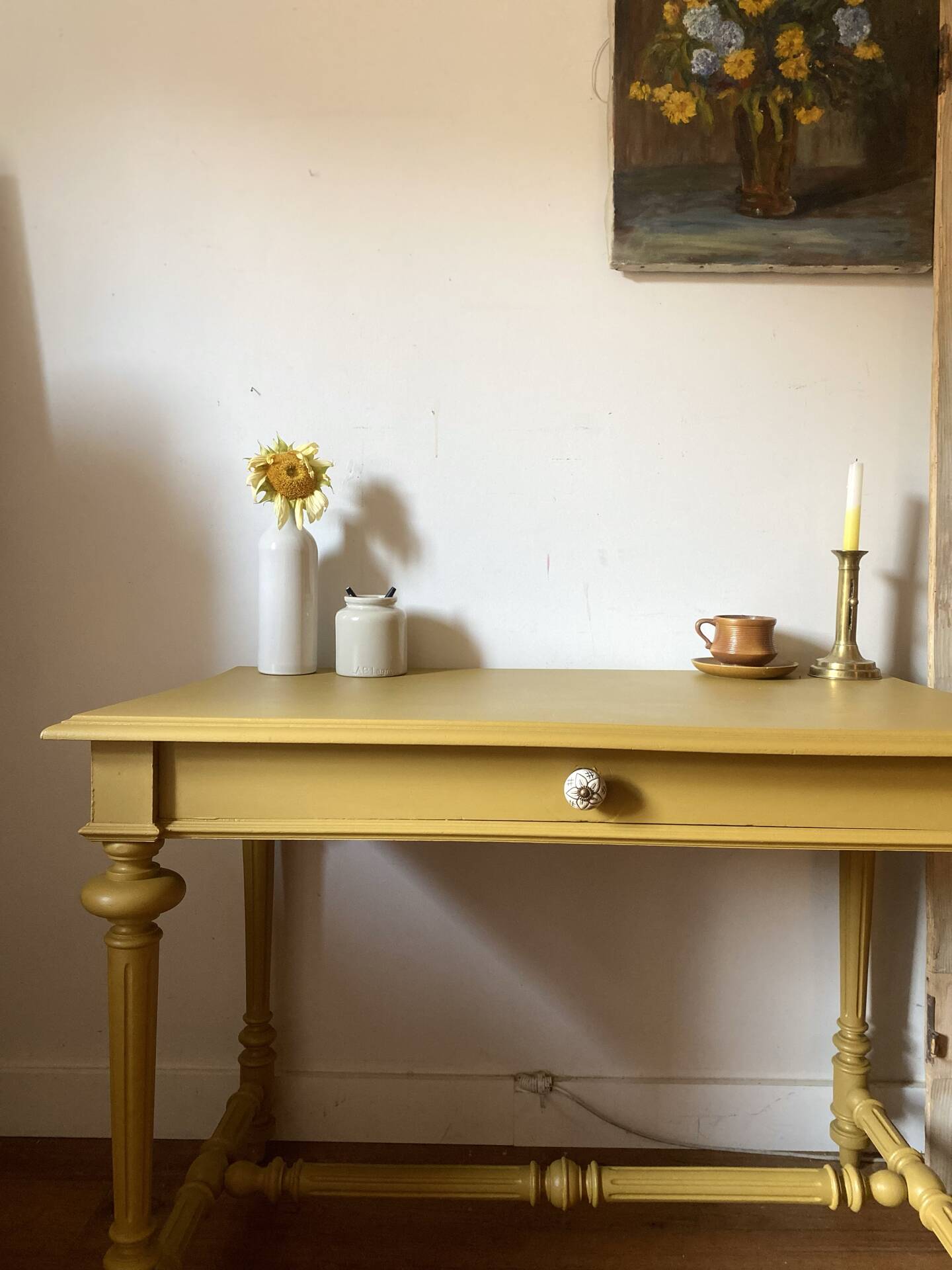 Desk table from the late 19th century, painted mustard, with turned stretcher.