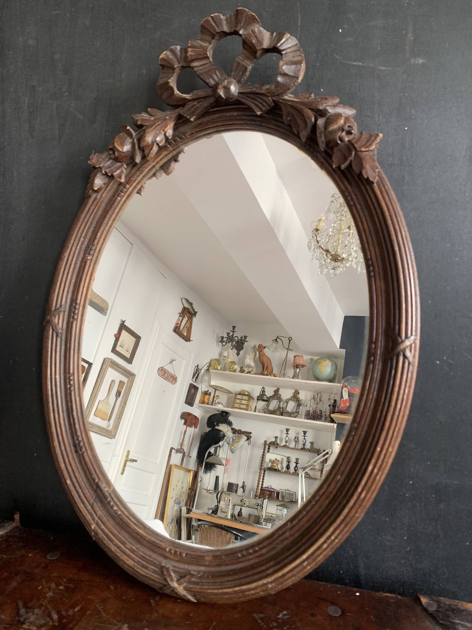 Antique oval mirror in carved wood and Louis XVI style knot