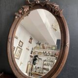 Antique oval mirror in carved wood and Louis XVI style knot