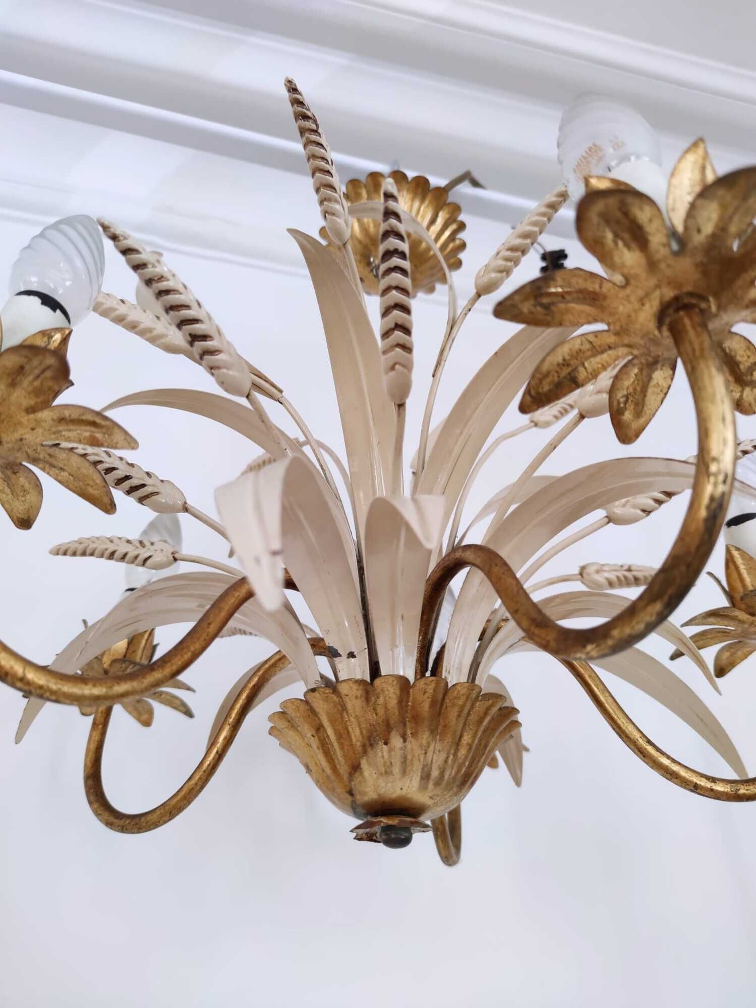Vintage wrought iron chandelier decorated with golden and beige reeds