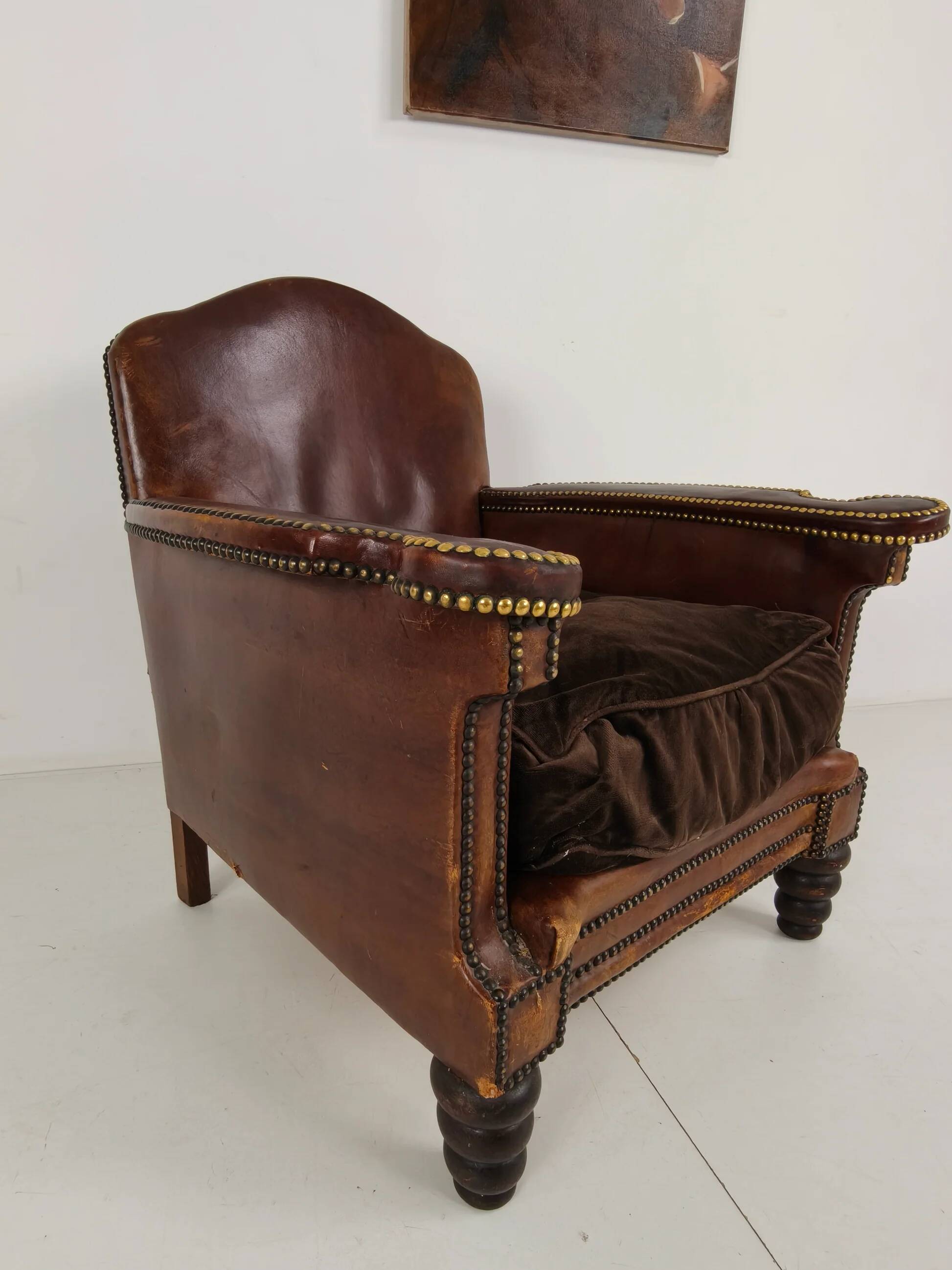 Antique leather club chair with stud detailing