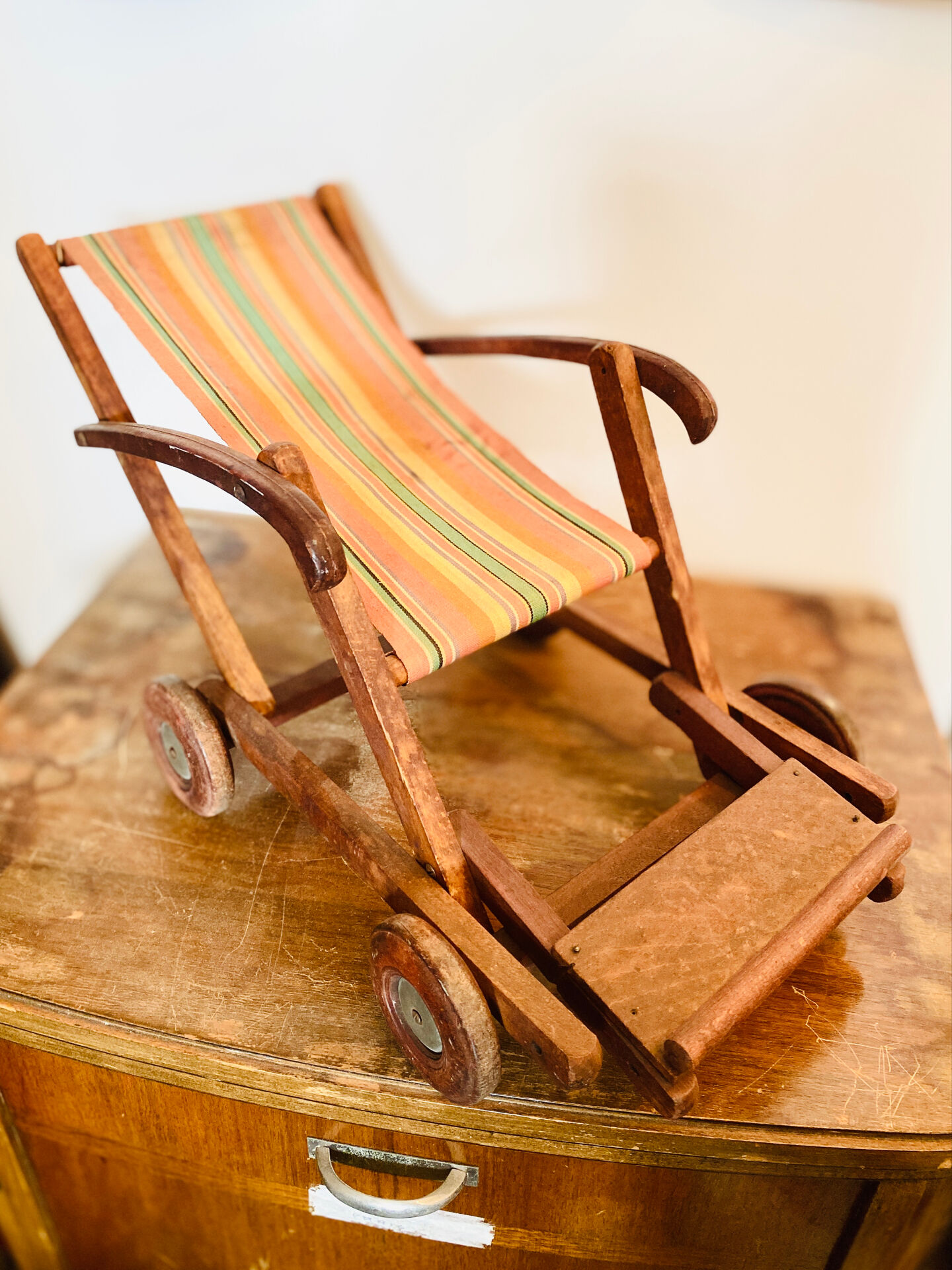 Vintage wooden folding doll's deckchair on wheels