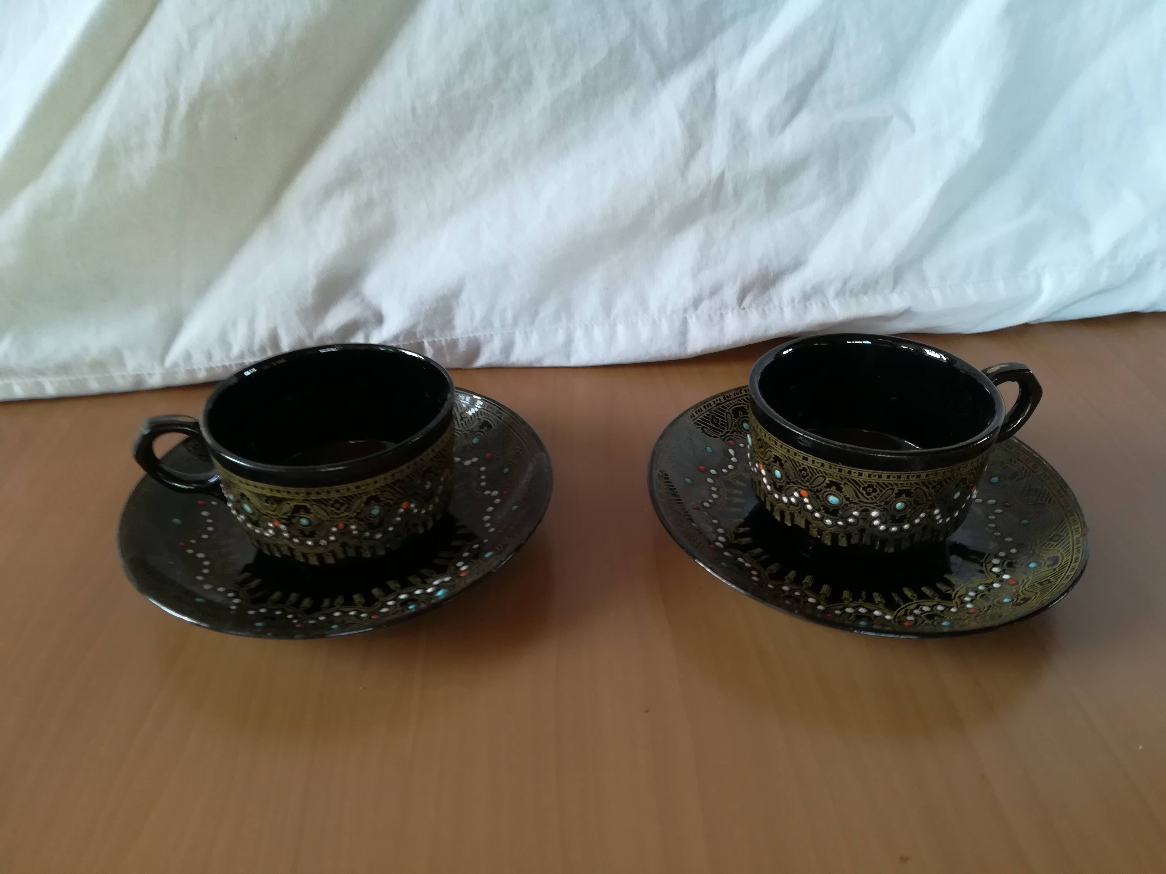Black cups and saucers with relief decoration