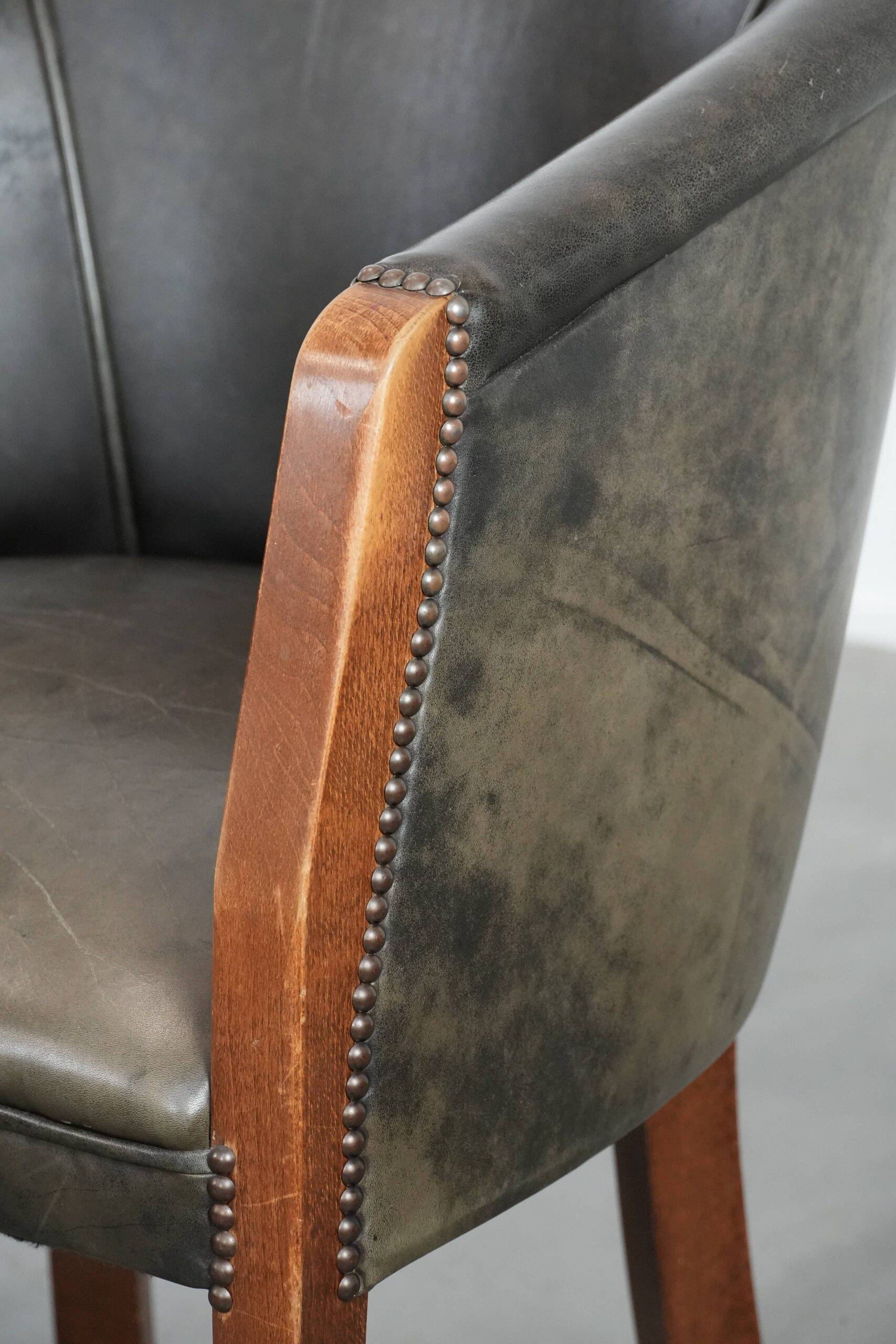 Set of two cowhide and wooden tub chairs with a sturdy colour scheme