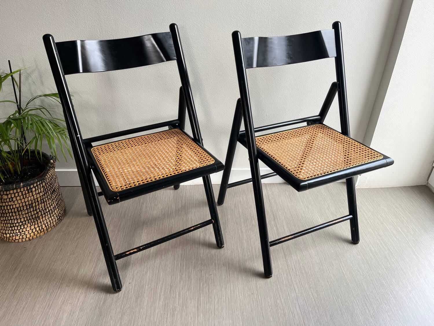 Vintage folding chairs in black wood and cane.